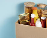 Cardboard box full of dried food goods and condiments