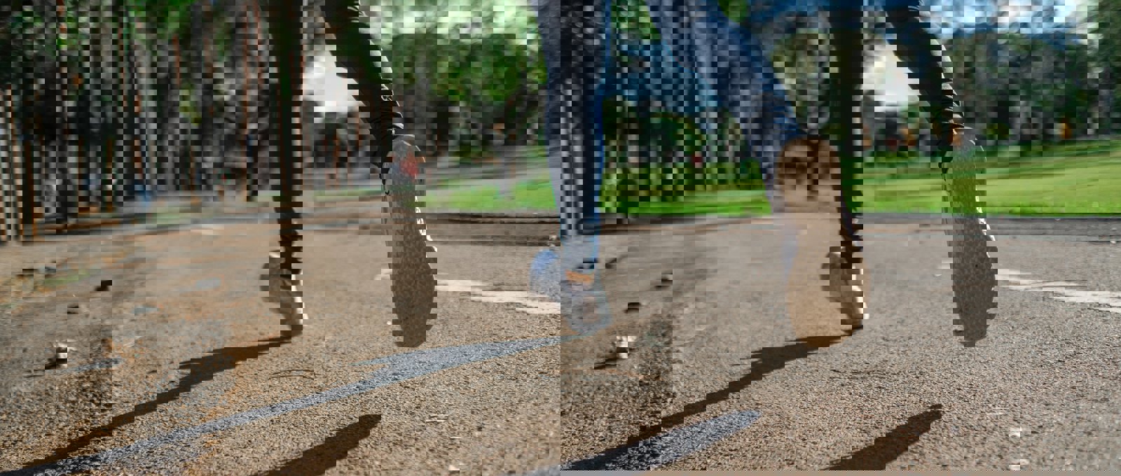 Close up photo of a woman's lower legs and feet taken as she jogs along a pathway in a park