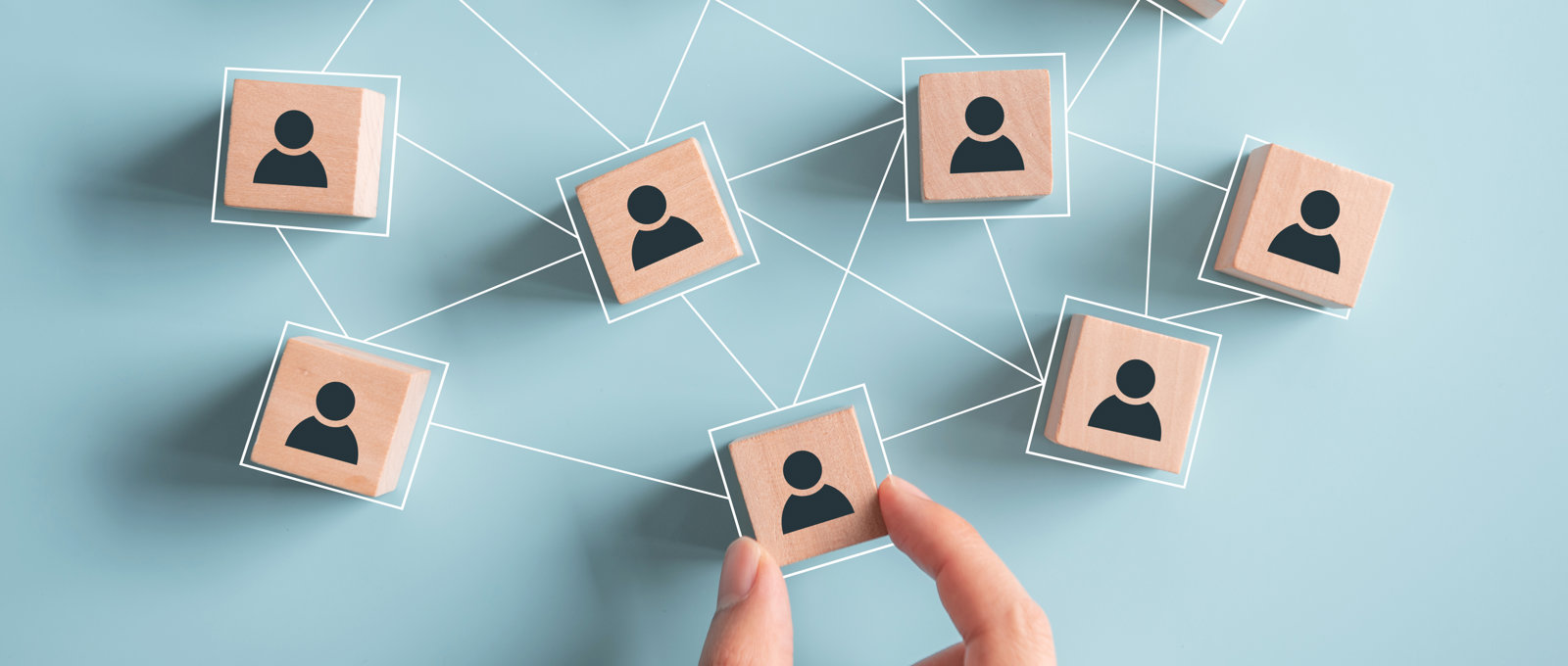 People icons printed on wooden cubes connected with straight white lines indicating a network of people